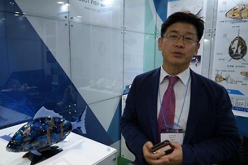 Oh Yong-joo Le PDG d'airo, à l'origine du poisson robot MIRO (à gauche), explique les caractéristiques de ce poisson robot intelligent, le 14 octobre 2016, lors du 11e salon robotique sud-coréen
