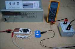 전기자극기의외장누설전류측정 정격전원전압의 +10% 의입력전원을사용하며, 그림왼쪽의시험개요와같이시험품의외장사이에흐르는누설전류를측정장치 (measuring device)