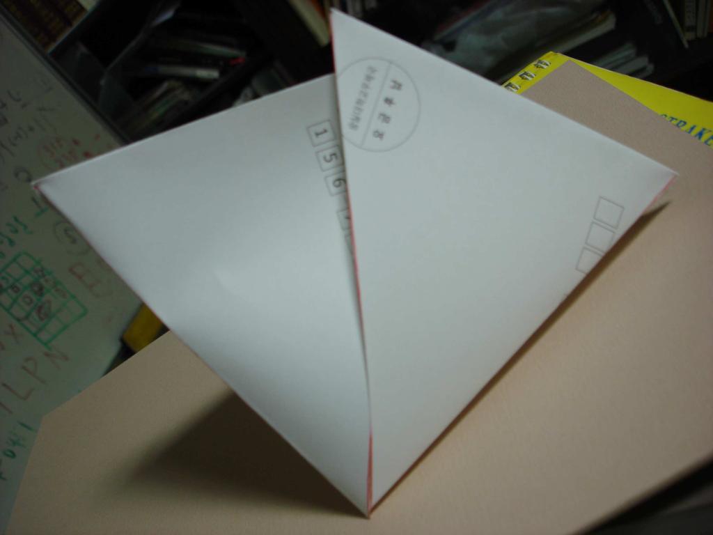 (4) 편지봉투를열어서한쪽을다른쪽속으로밀어넣으면사면체가만들어진다.