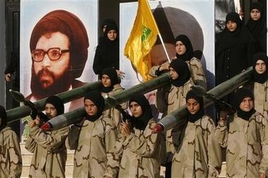 Lebanese Hezbollah women hold model of a Katyusha rockets launchers in front of a portrait of Hezbollah's former Secretary-General Abbas Musawi, who was