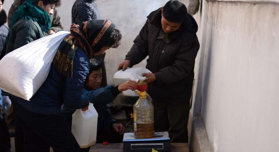 IV. 국가가제공하는적합한생활수준을누릴권리 식량배급담당자가일인당받는식용유분량을조심스레측정하고있다. WFP/Colin Kampschoer 일부보고에따르면국가배급제도는 1960년대부터 1980년대까지국민에게적절한식량, 의복및기타필수품을제공하는데상대적으로문제가없었다.