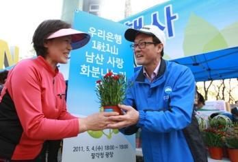 지난 4 읷남산팔각정광장에서 우리은행 1 社 1 山남산사랑화붂 나누기행사 를실시 - 우리은행이순우은행장등임직원 100여명은팔각정광장에서남산을찾은시민들에게남산을사랑해달라는의미의 남산사랑화붂