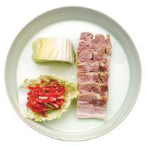 bossam [ 보쌈 ] E Boiled pork wrapped in cabbage leaves with a spicy relish made of sliced radish.
