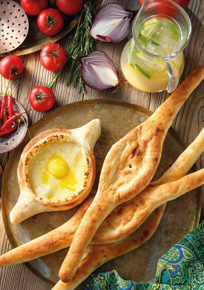 Adjaruli Khachapuri Bread in an open boat shape stuffed with Imeretian and Sulguni cheese and topped with melting butter and lightly cooked egg yolk.